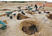 Vue générale dans la zone centrale en cours de fouille : les puits ouverts chacun les uns à côté des autres donnent accès à de courtes galeries permettant de suivre les filons de silex. Le Fresne, Ri (Orne), 2007.