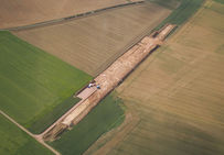 Vue aérienne de la fouille : les taches de limon brun correspondent à l’ouverture des puits de mines. Le Fresne, Ri (Orne), 2007.